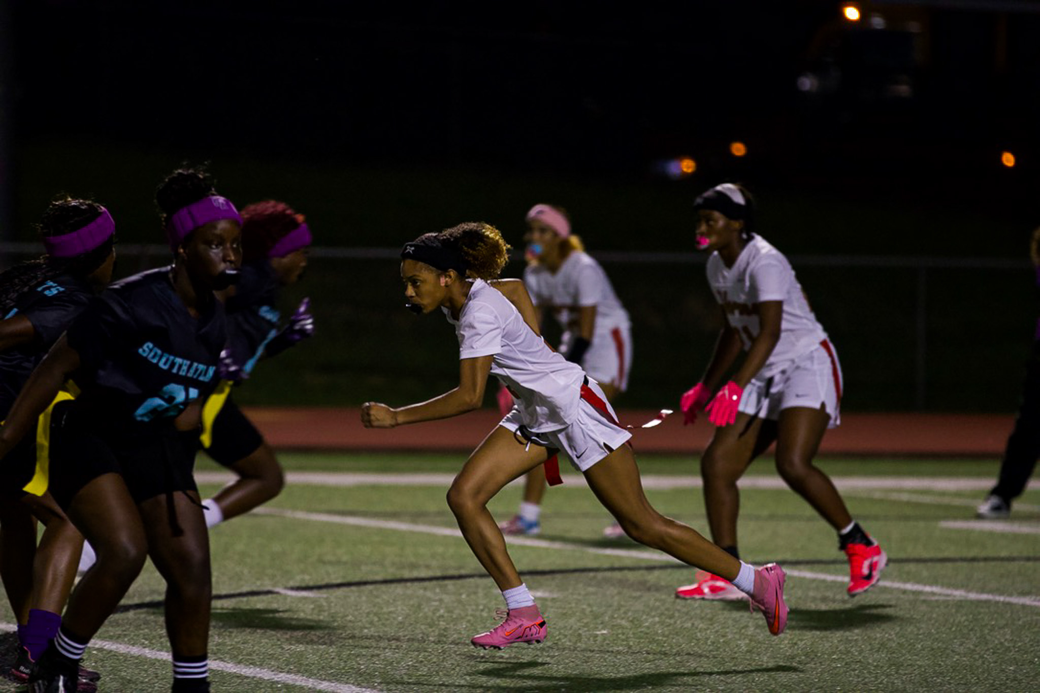 Flag football player running through defenders