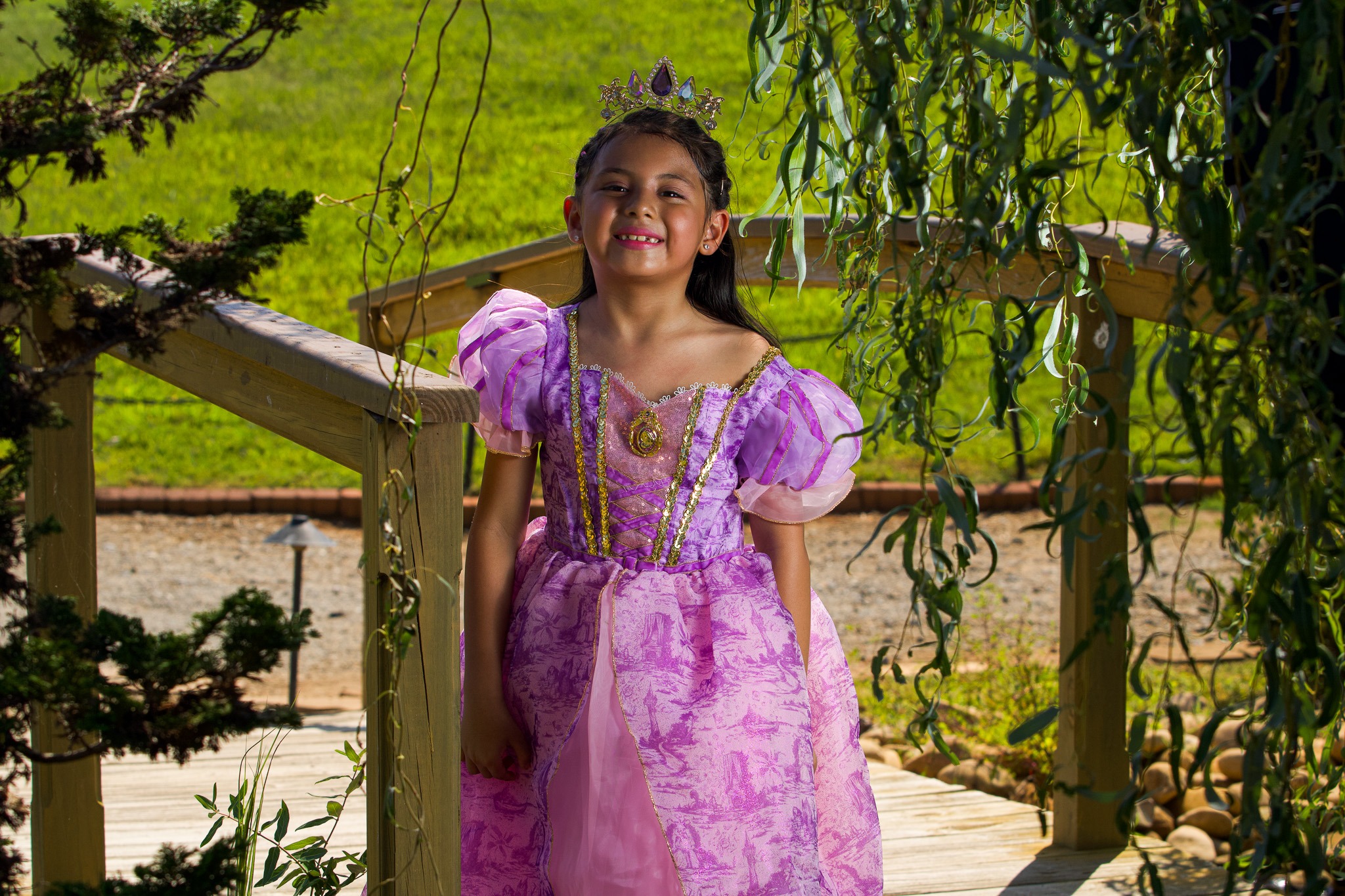 Young princess smiling beneath hanging tree branches