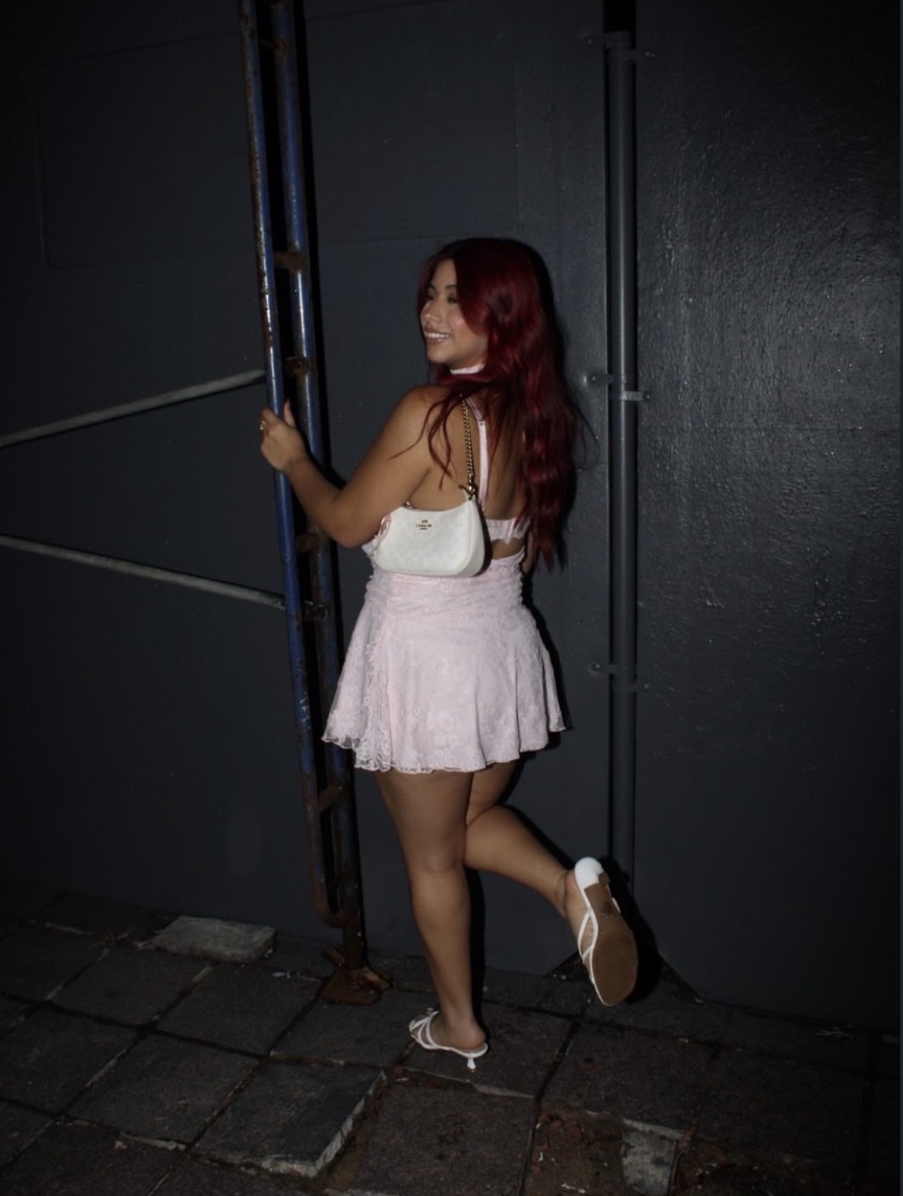 Evening fashion portrait against a dark architectural backdrop