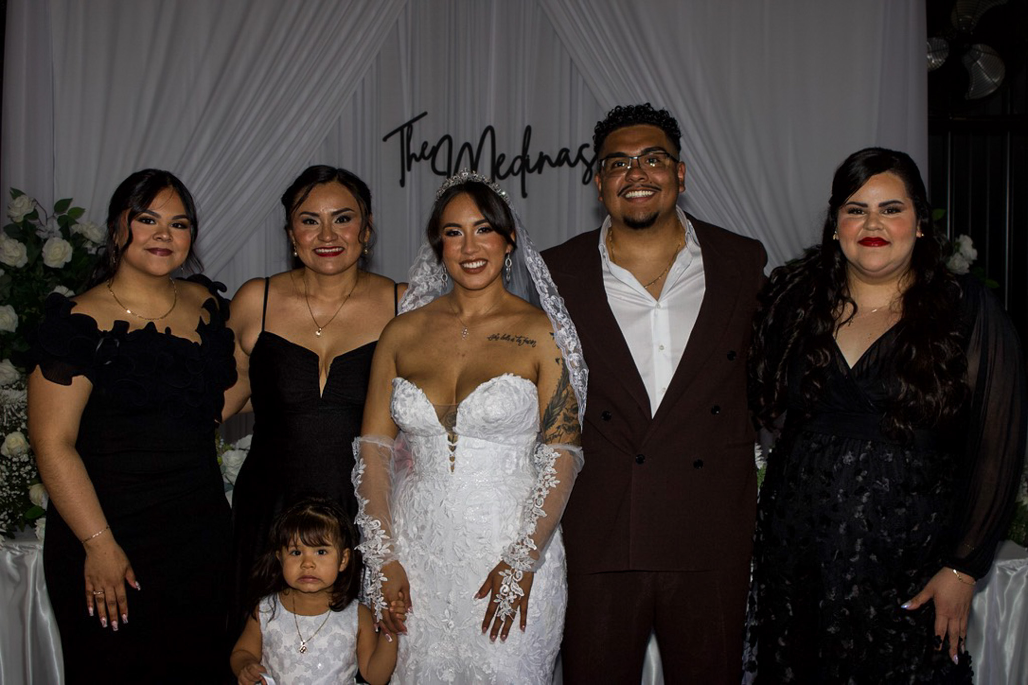 A newlywed couple surrounded by family
